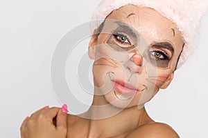 Beautiful woman with moisturizing leopard face mask. Mask with leopard, cat.