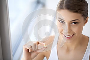 Beautiful Woman Mouth Holding Pill For Teeth. Girl Taking Vitamins