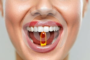 Beautiful Woman Mouth With Pill In Teeth. Girl Taking Vitamins