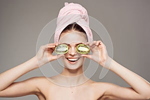 beautiful woman with naked body with fruit kiwi in hand cropped view