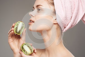 beautiful woman with naked body with fruit kiwi in hand cropped view