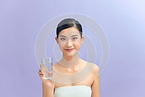 Beautiful woman with naked shoulders drinking a glass of water