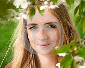 Beautiful woman in nature, framed by spring blossoms