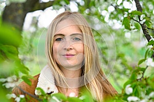 Beautiful woman in nature, framed by spring blossoms