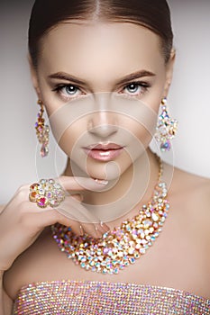 Beautiful woman in a necklace, earrings and ring. Model in jewel