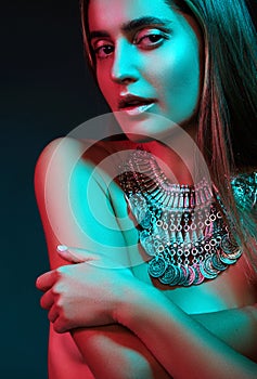 Beautiful woman in a necklace. Model in jewelry from silver. Beautiful indian jewellery. Bright lights