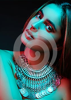 Beautiful woman in a necklace. Model in jewelry from silver. Beautiful indian jewellery. Bright lights