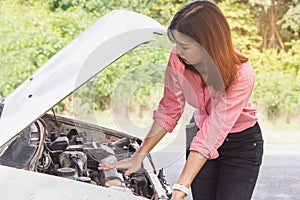 Beautiful woman need help. Woman trying to fix car engine on the road