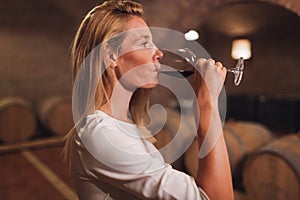 Beautiful woman oenologist tasting wine