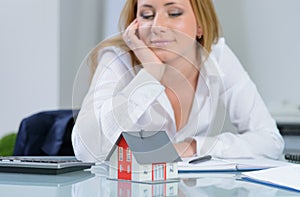 Beautiful woman at office dreaming about own home