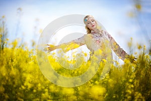 Beautiful woman in oilseed flowers