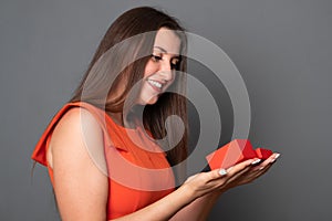 Beautiful woman opens a box with a gift. Happy young woman holding a gift