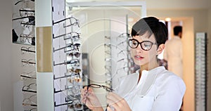 Beautiful woman with optician trying eyeglasses