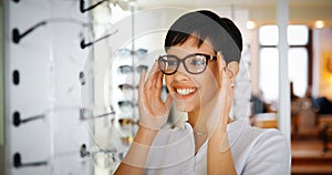 Beautiful woman with optician trying eyeglasses