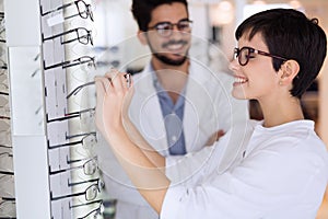 Beautiful woman with optician trying eyeglasses