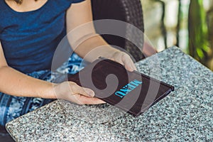 Beautiful woman ordering from menu in restaurant and deciding what to eat