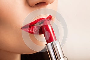 Beautiful woman paints lips with lipstick. Beautiful woman face.