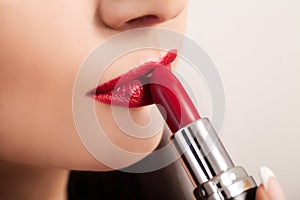 Beautiful woman paints lips with lipstick. Beautiful woman face.