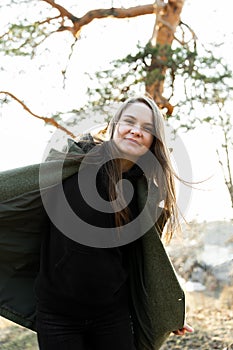 Beautiful woman in a park smiling happy. Joyful young woman dancing in a spring park