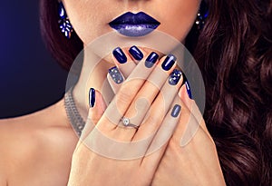 Beautiful woman with perfect make-up and blue manicure wearing jewellery