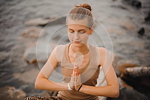 Beautiful woman performing namaste gesture with closed eyes