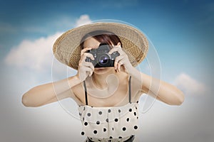 Beautiful woman photographer holding photo camera