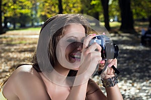 Beautiful woman photographing summer park