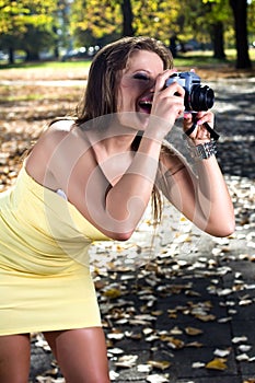 Beautiful woman photographing summer park