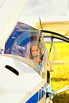 Beautiful woman the pilot in a cockpit of the ultralight plane