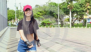 beautiful woman in pink cap skating in the park outdoors having fun photo