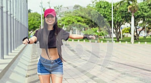 beautiful woman in pink cap skating in the park outdoors having fun photo