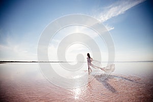 Beautiful woman on a pink lake.