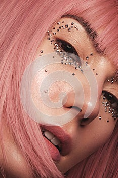 Beautiful woman in a pink wig and creative makeup with rhinestones. Beauty face.