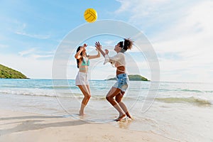 beautiful woman playing ball on the beach