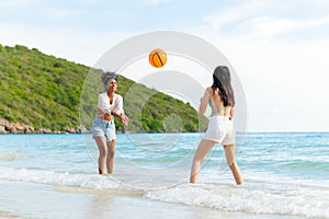 beautiful woman playing ball on the beach