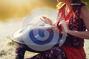 beautiful woman playing with hangdrum in nature.