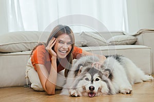 beautiful woman playing with her dog in room at home happily