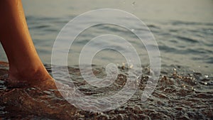 Beautiful woman playing in ocean at dreamy golden sunset