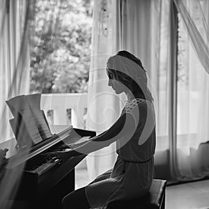 Beautiful woman playing piano. Black and white