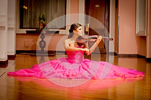 Beautiful woman playing violin with big dress