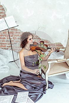 Beautiful woman playing the violin bow rose