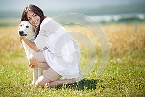 Beautiful woman plays with the dog on the Meadow