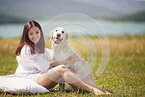 Beautiful woman plays with the dog on the Meadow