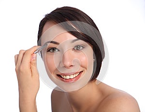 Beautiful woman plucking eyebrow with tweezers