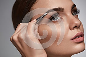 Beautiful Woman Plucking Eyebrows. Beauty Brows Correction