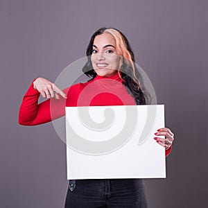 Beautiful woman pointing at a blank whiteboard