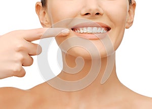 Beautiful woman pointing to teeth