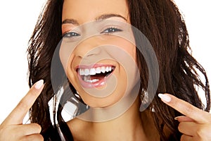 Beautiful woman pointing to teeth.