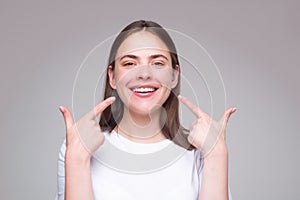 Beautiful woman pointing to teeth. Beautiful smile with white teeth. Closeup smiling woman mouth. Dental health.