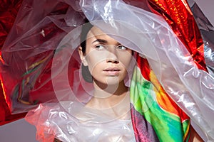 Beautiful woman in polyethylene wearing a huge hat.